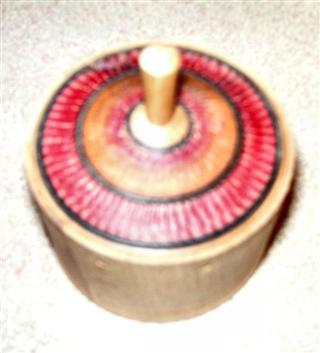A dreidal. The base is textured to simulate a brick wall and the lid is a spinning top